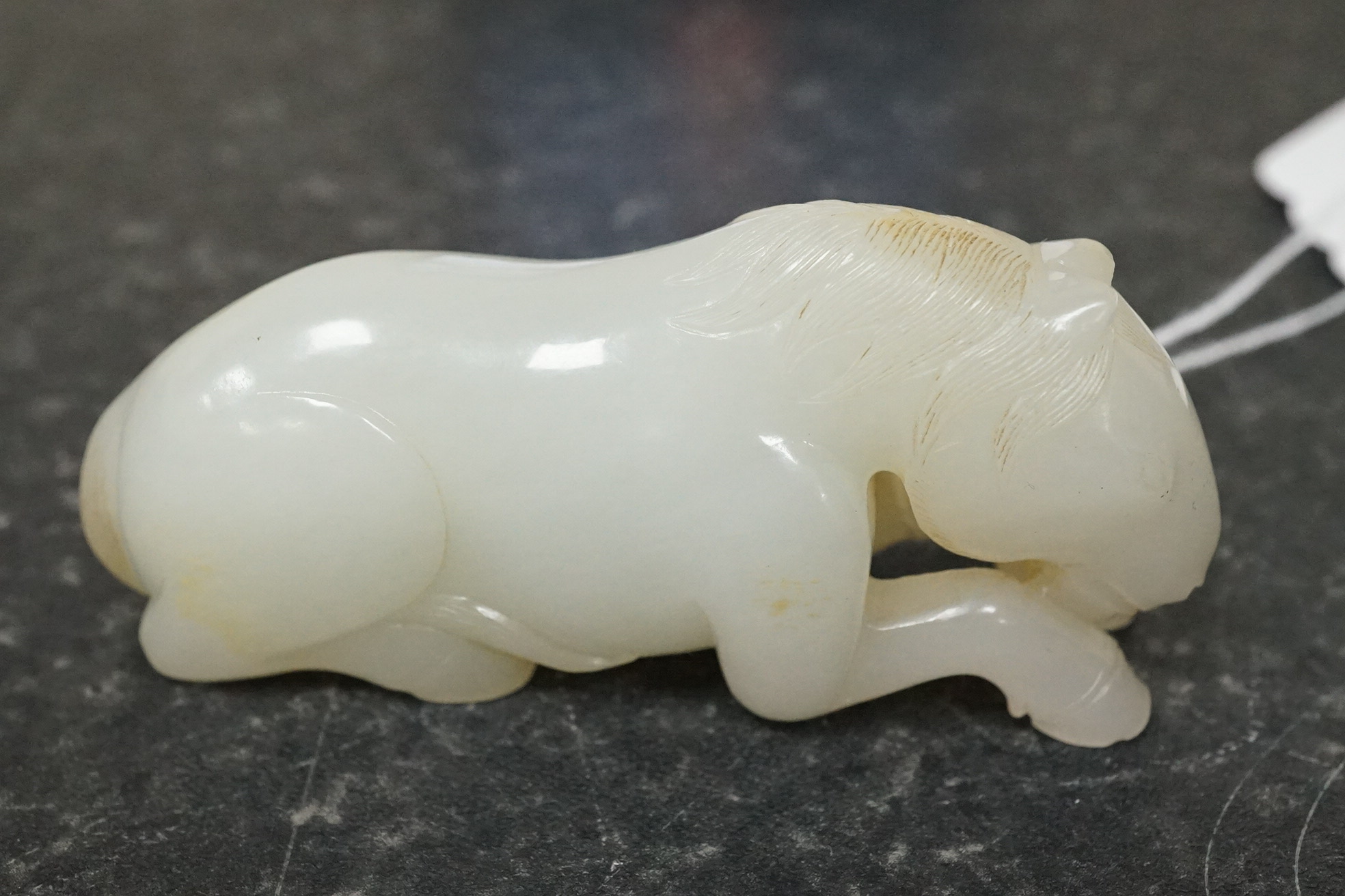 A Chinese white jade figure of a recumbent horse